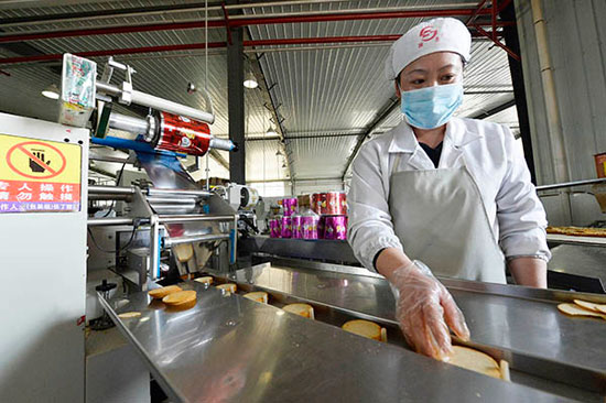 5月4日，西吉县一家马铃薯加工企业工作人员在生产线上将刚生产出的马铃薯薄脆饼干进行筛选包装